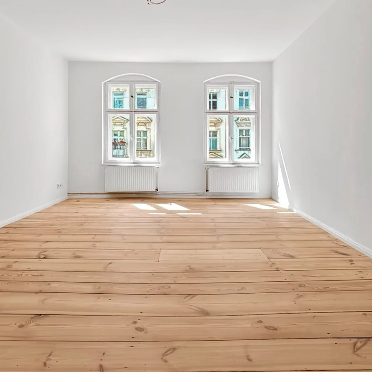 Zimmer mit zwei Altbaufenstern und neu verlegten Berliner Profil-Sockelleisten