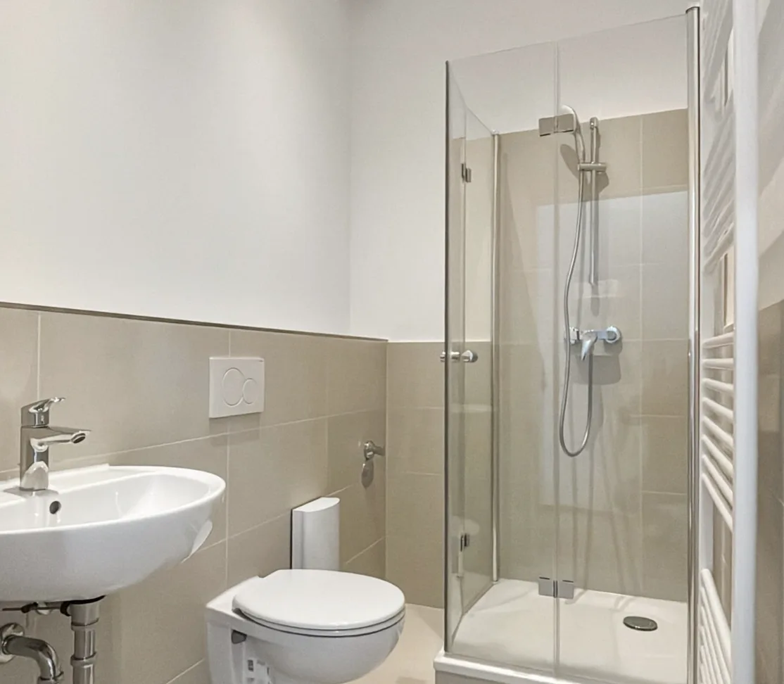 Saniertes Badezimmer in Berlin-Kreuzberg mit Eck-Duschkabine, Wand-WC und Wandwaschbecken