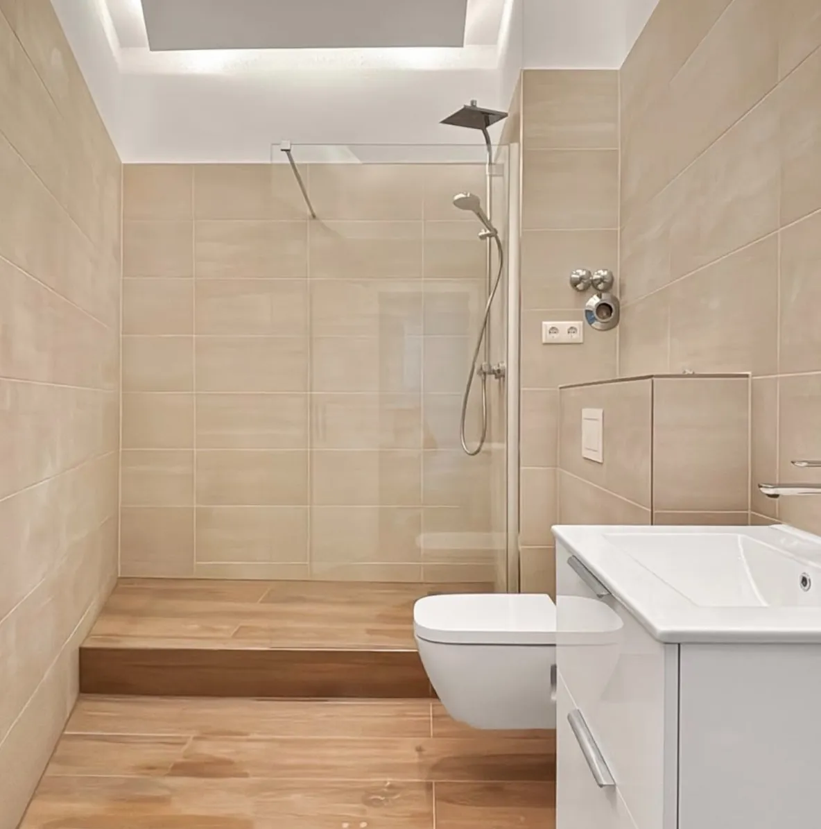 Begehbare Dusche mit Echtglas-Trennwand unter der Trockenbaudecke mit indirekter LED-Beleuchtung