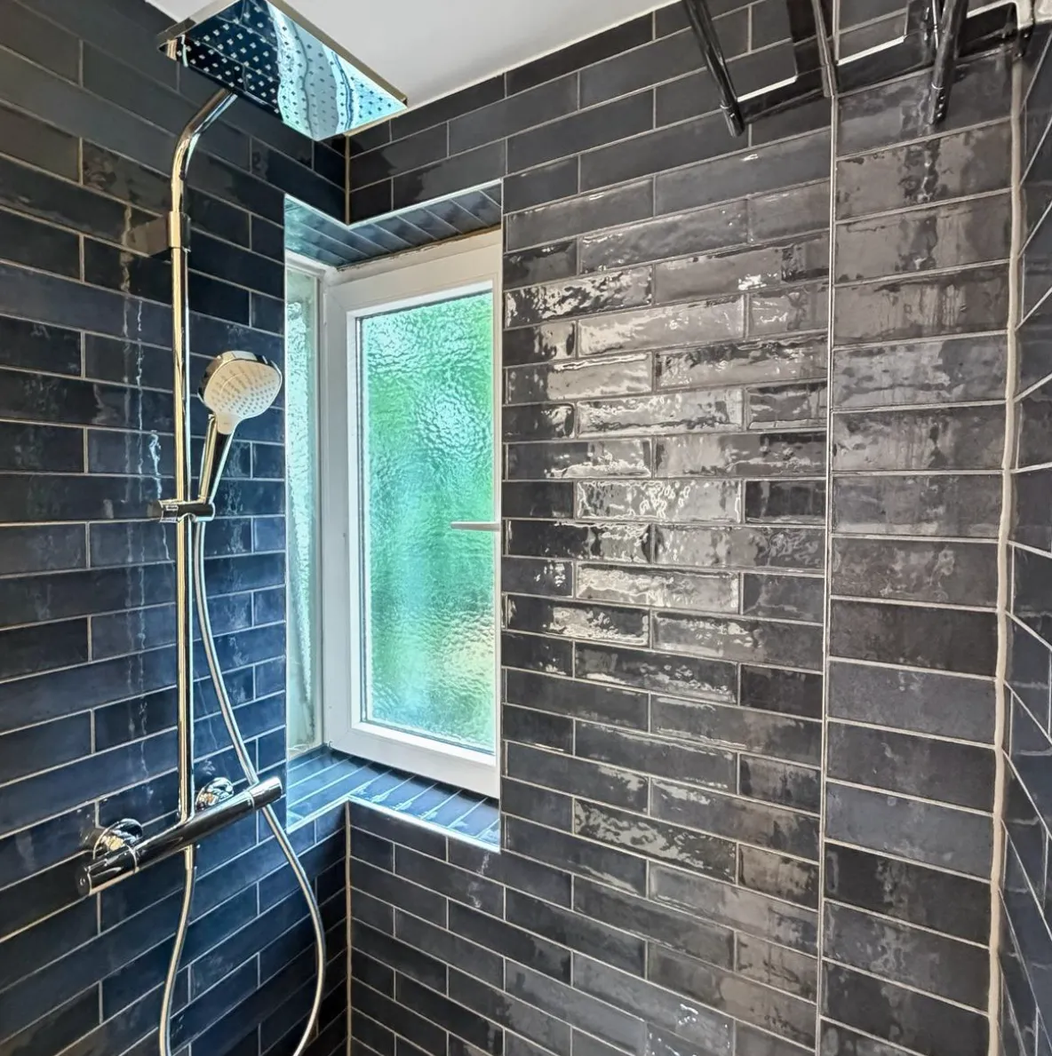 Regenduscharmatur in der Dusche vor dem Fenster, Wände mit Metrofliesen