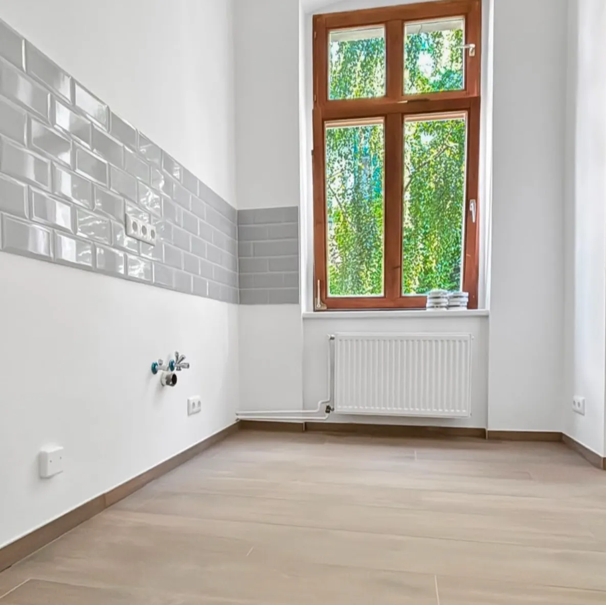 Küche mit neuem Fliesenspiegel, Bodenfliesen in Holzoptik und lackiertem Heizkörper
